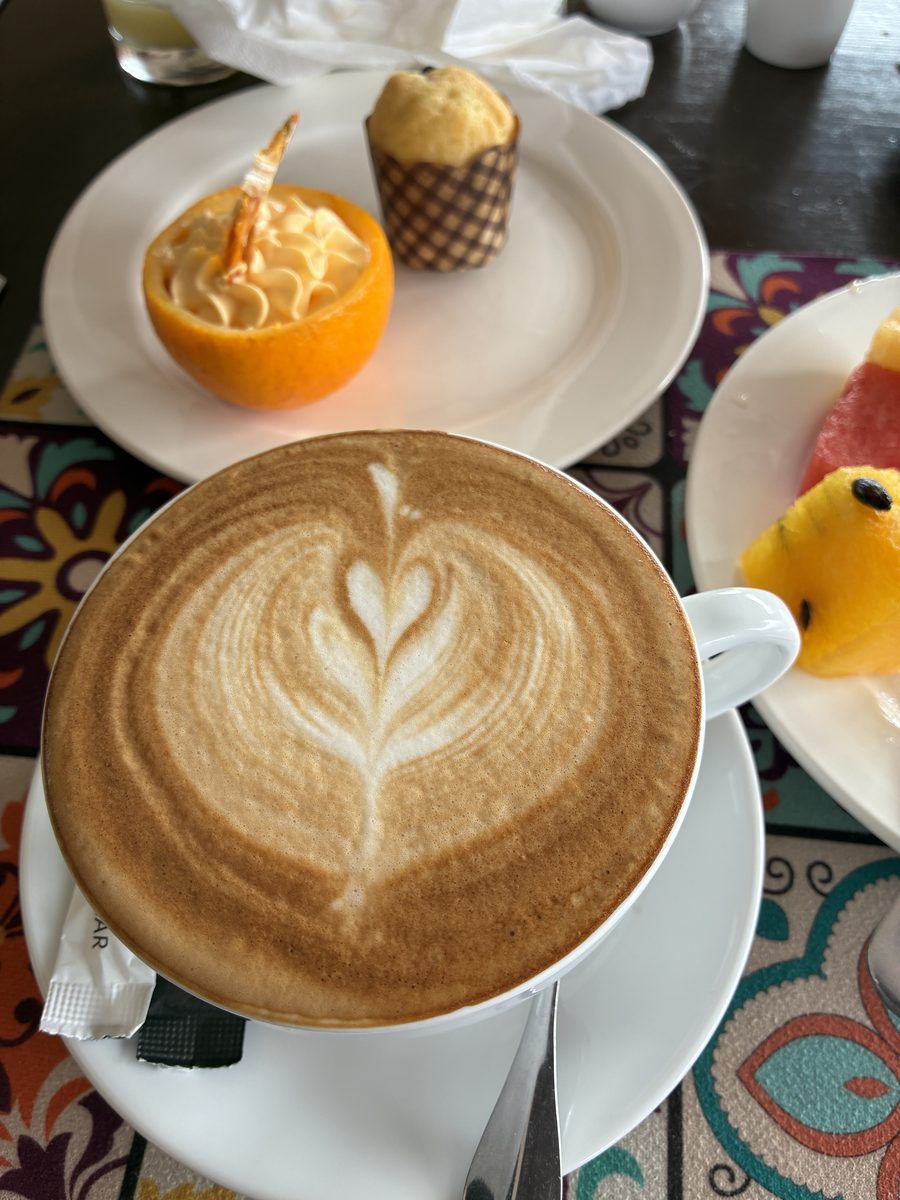 スタッフの方が淹れてくれたカフェラテと、朝食のマフィンとフルーツ