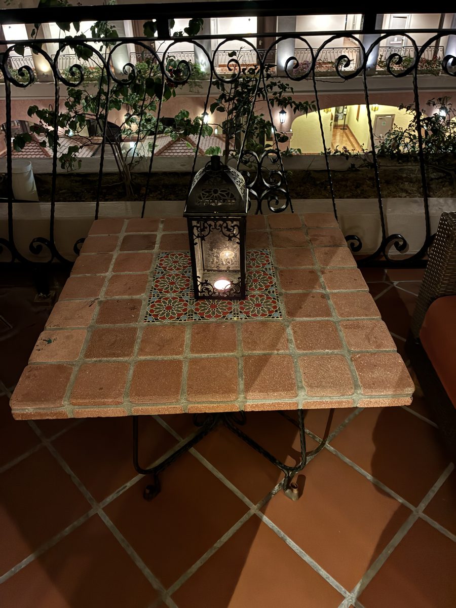 夜のテラス。ランタンに灯がともり、中庭の明かりが見える